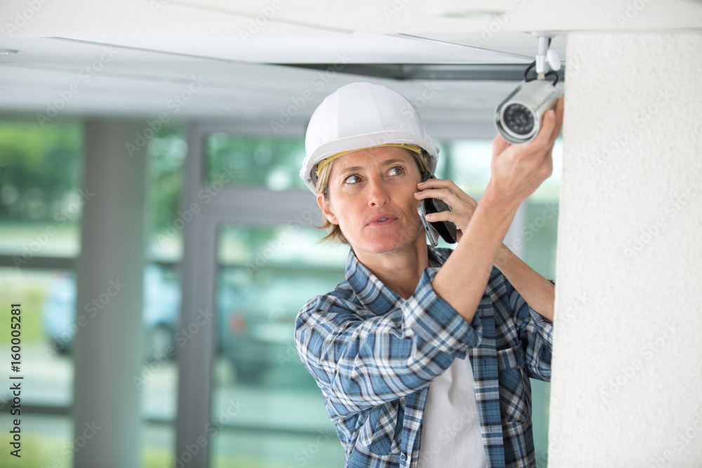 middle-age female professional cctv technician working middle-age female professional cctv technician working