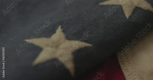 American flag detail with red and white stripes with field of blue and circle of 13 stars, the flag designed by Betsy Ross during the American Revolution. Shot in cinematic 4K.