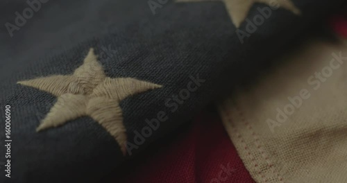 American flag detail with red and white stripes with field of blue and circle of 13 stars, the flag designed by Betsy Ross during the American Revolution. Shot in cinematic 4K.