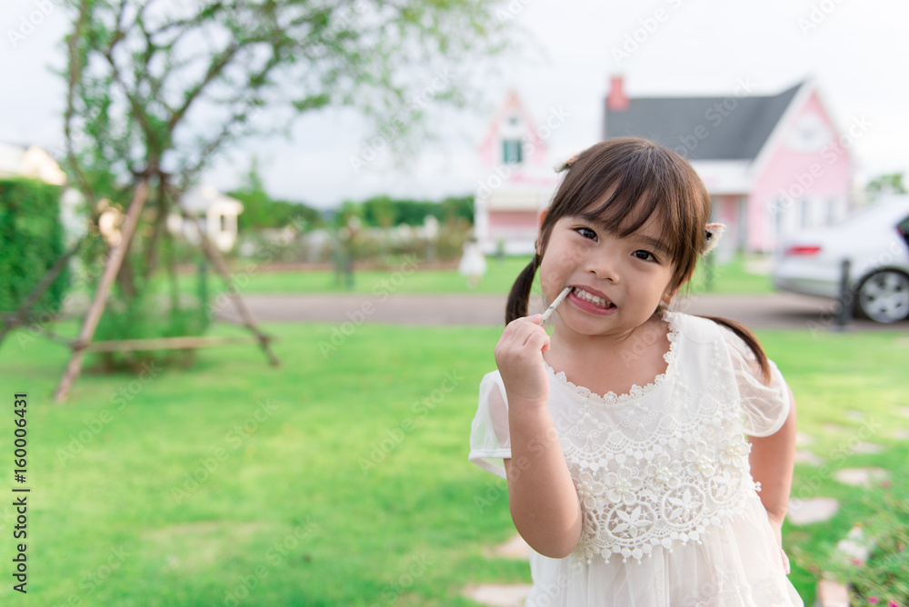 Cute little girl eating snack in the park,happy,fun,bright tone Cute little girl eating snack in the park,happy,fun,bright tone