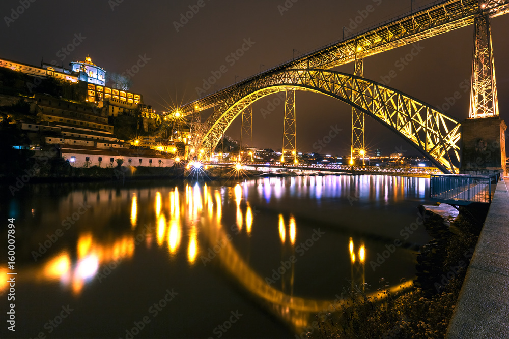 Dom Luis I or Luiz I iron arch bridge across Douro river with reflection and Monastery of Serra of Pilar in Porto at night, Portugal.