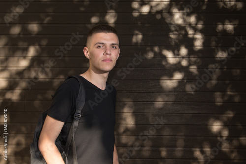 Teenage Boy looking at camera on background of Urban wall