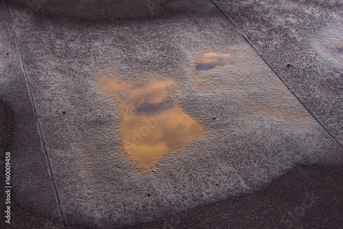 Evening sky reflected in a puddle