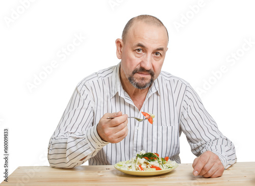 Man eating the salad with a raw vegetables
