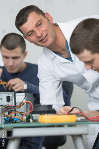 students in technology fixing computer processing