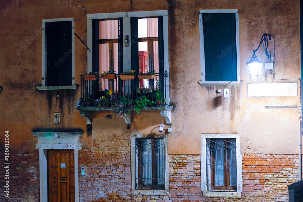 Fototapeta premium Venice, Italy, May, 31, 2017: facade of an inhabitable house at night in Venice, Italy