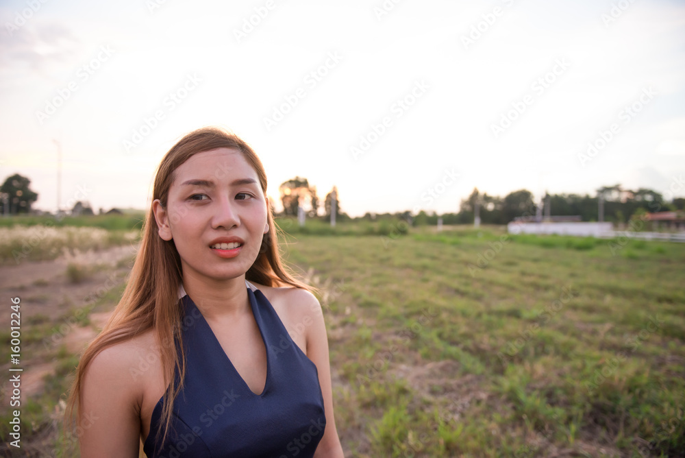 Beautiful asian woman think something  in the fields on sunset