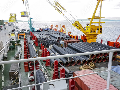 The deck lay barge. Pipes and Lifting cranes on the ship. Equipment for laying a pipeline on the seabed