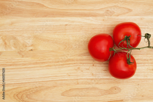 Red vine ripe tomatoes on wood background