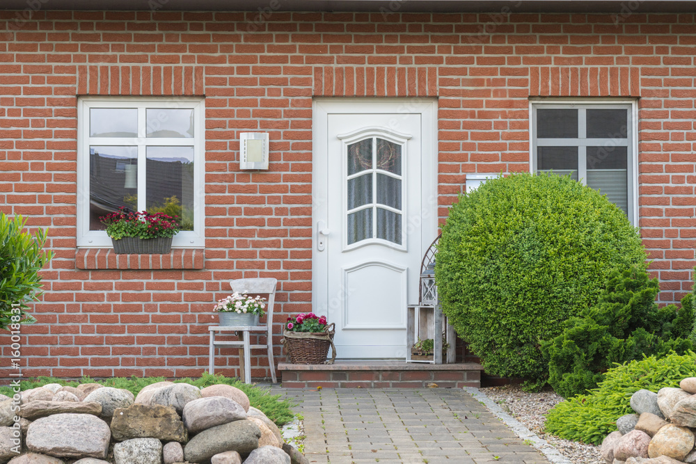 Obraz premium Weiße Tür eines Hauses mit weißen Fenstern