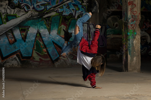 Female urban dancer standing on one hand