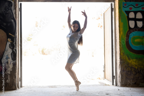 Pretty ballerina performing outdoors