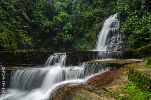 Fototapeta Naklejka Na Ścianę i Meble -  beautiful in nature, amazing cascading tropical waterfall. wet and mossy rock, surrounded by green rain forest