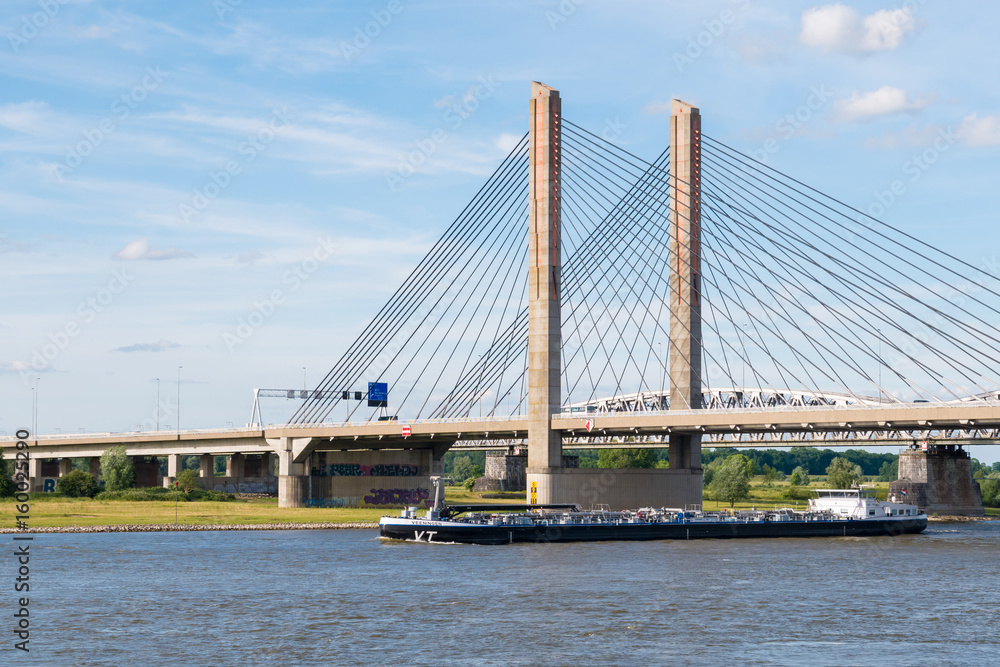Fototapeta premium Tanker and Martinus Nijhoff Bridge, Waal river near Zaltbommel, Netherlands