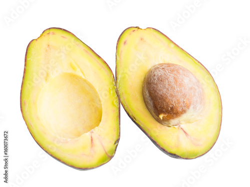 ripe avocado fruit sliced across a half showing portion detail and core isolated on white