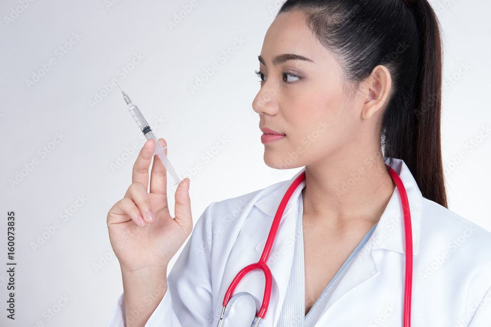 Confident smiling female doctor with a syringe in hand. Portrait of a young medical staff ready to make injection. physician or practitioner on white background Confident smiling female doctor with a syringe in hand. Portrait of a young medical staff ready to make injection. physician or practitioner on white background
