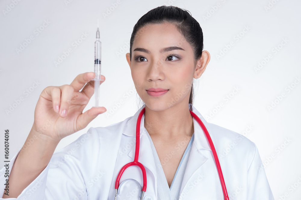Confident smiling female doctor with a syringe in hand. Portrait of a young medical staff ready to make injection. physician or practitioner on white background Confident smiling female doctor with a syringe in hand. Portrait of a young medical staff ready to make injection. physician or practitioner on white background