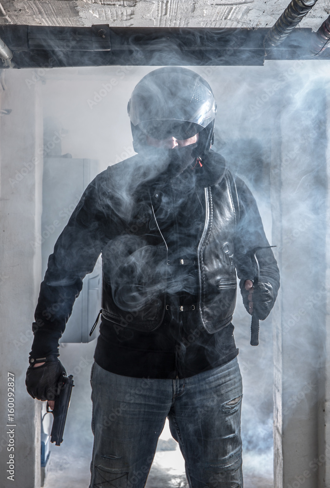 Fototapeta premium A burglar enters a building with a gun and a crowbar