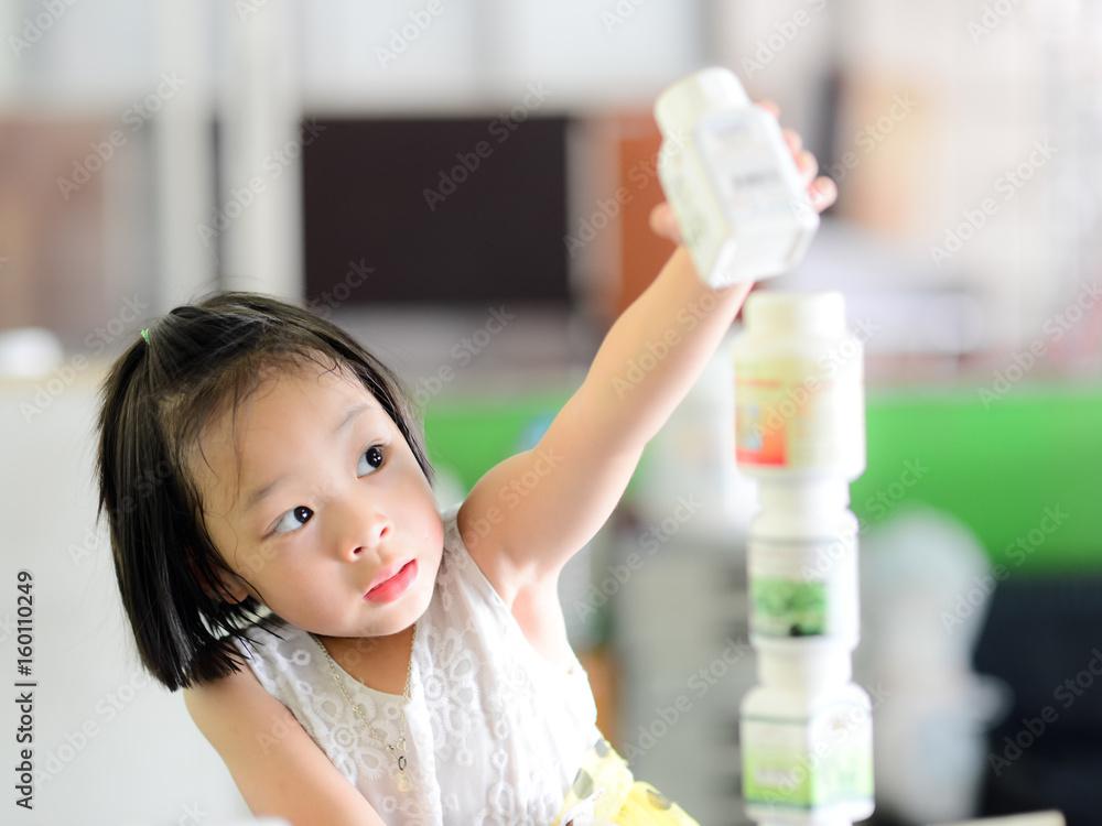 Asian girl playing block by plastic bottle at home, lifestyle concept Asian girl playing block by plastic bottle at home, lifestyle concept