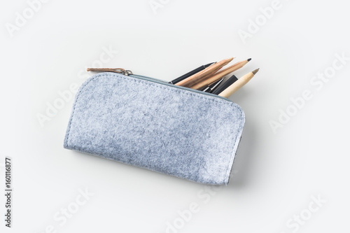 Картината върху платно Top view of grey fabric pencil case with lot of pens on white background desk fo