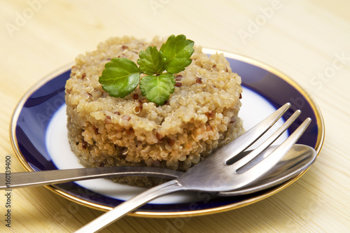 Quinoa dish and fork on wooden table