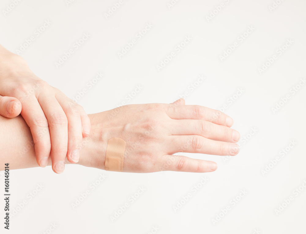 Sticking plaster on hand on white background Sticking plaster on hand on white background