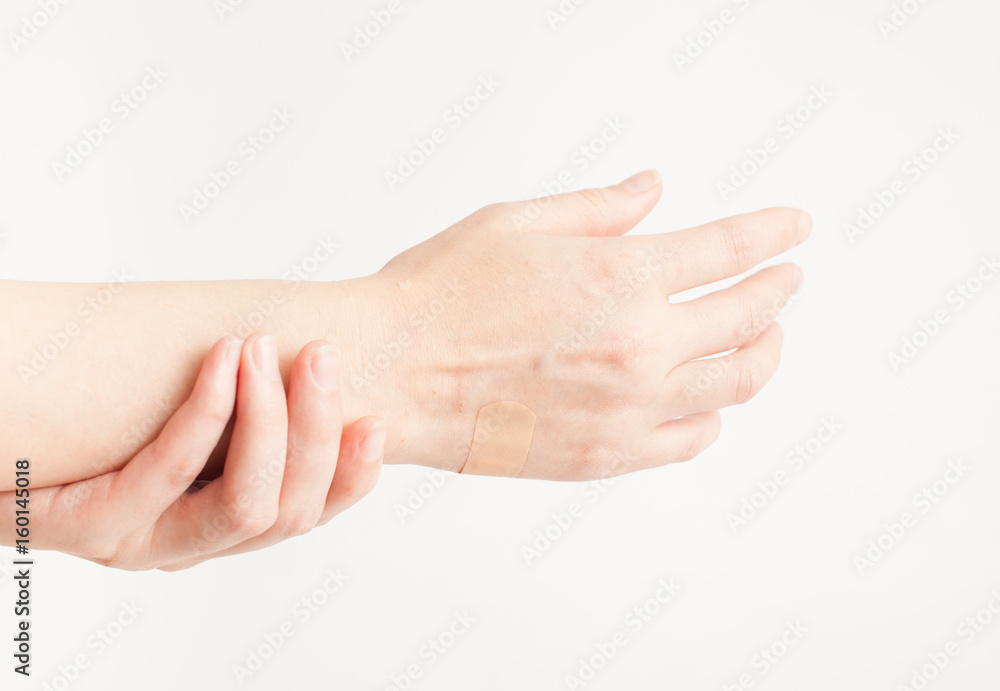 Sticking plaster on hand on white background