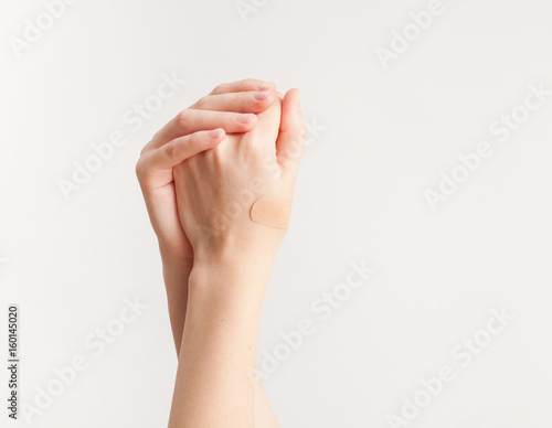 Sticking plaster on hand on white background