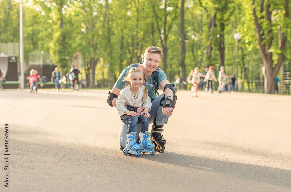 Fototapeta premium little girl and her father posing and roller skating