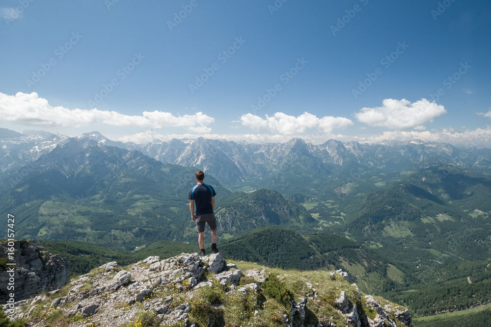 Man on top of a mountain looking at mountain range