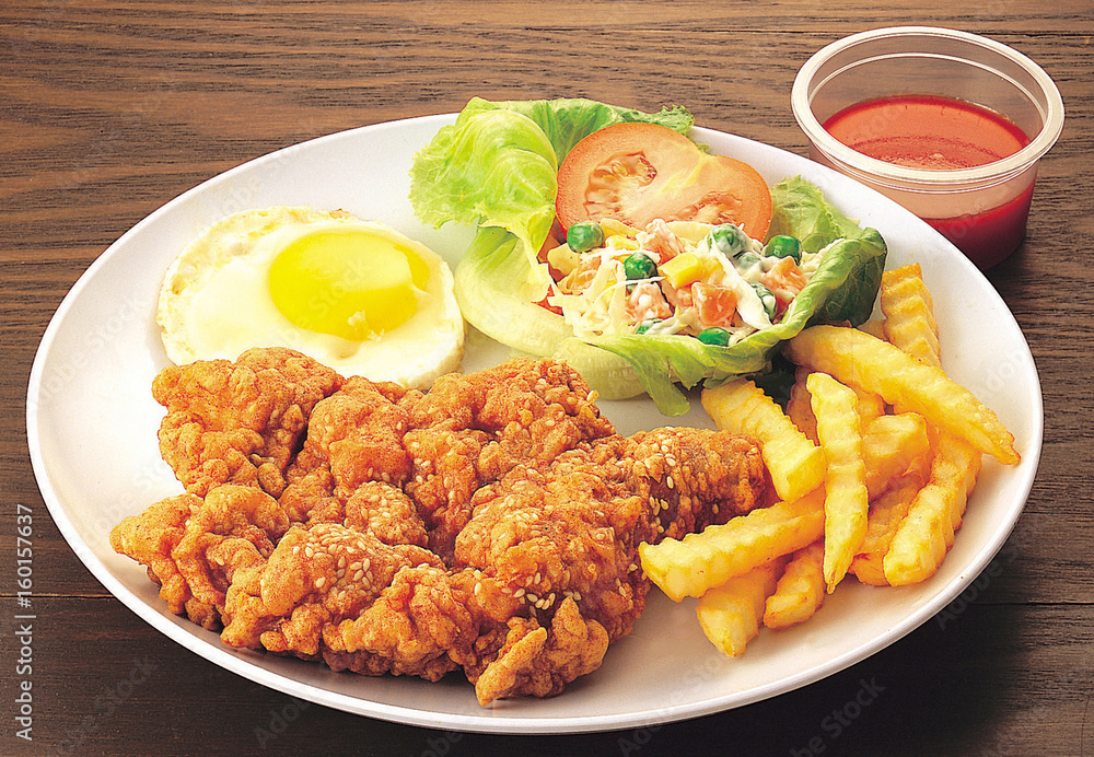 Chicken chop meal served with fried egg, french fries and salad Chicken chop meal served with fried egg, french fries and salad