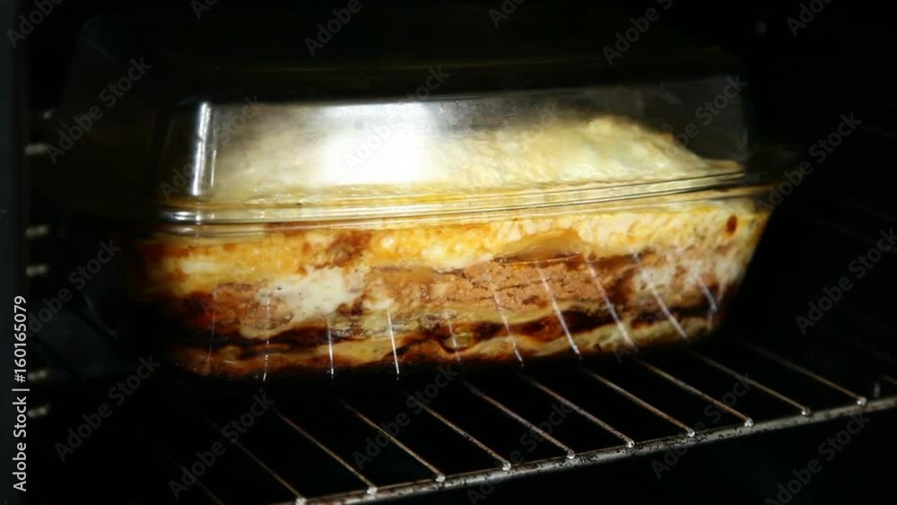 Lasagna is boiling in a transparent saucepan in the oven Lasagna is boiling in a transparent saucepan in the oven