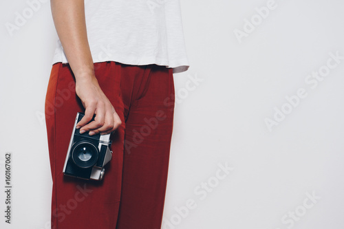 Woman holding a vintage camera front a white background