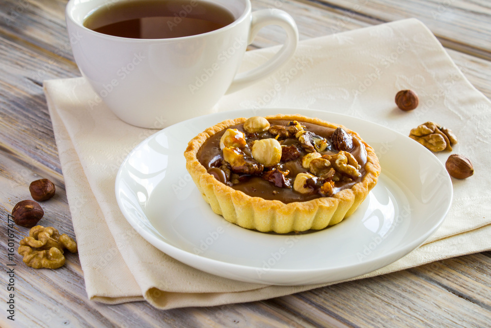 Baking with nuts and tea on the light brown wooden background 