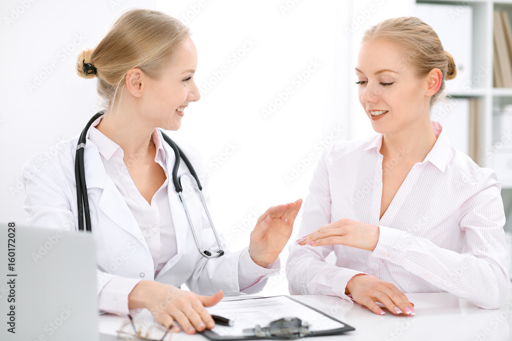 Doctor and patient sitting at the desk Doctor and patient sitting at the desk