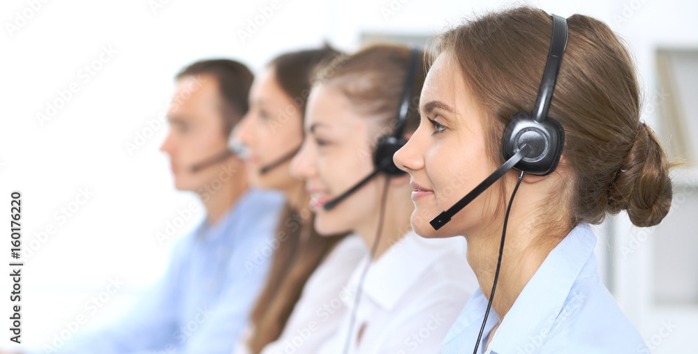 Call center operator in headset while consulting client. Telemarketing or phone sales. Customer service and business concept Call center operator in headset while consulting client. Telemarketing or phone sales. Customer service and business concept
