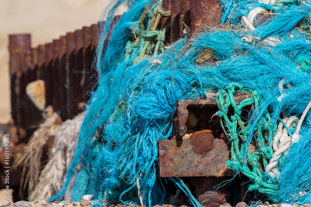 Plastic sea pollution. Tangled nylon fishing net caught up on a