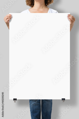 Woman holding a blank A1 poster mockup isolated on a gray background.