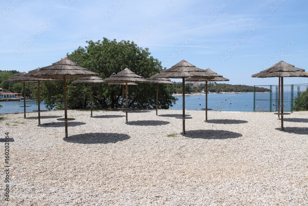 viele Sonnenschirme am Strand