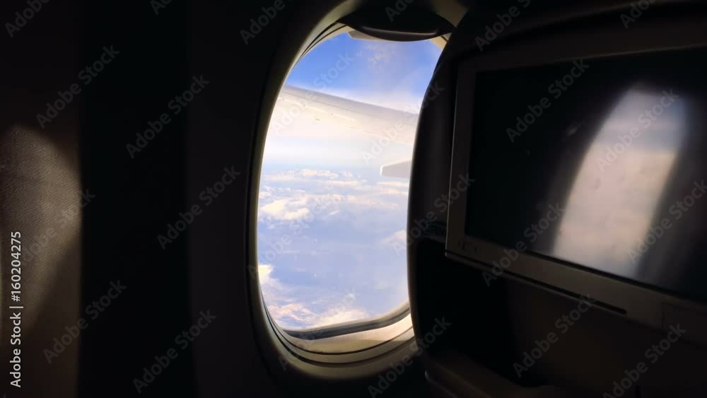 A young girl travels by plane and sits by the window and enjoys the view and then closes the porthole. 1080p A young girl travels by plane and sits by the window and enjoys the view and then closes the porthole. 1080p