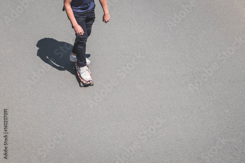 boy on skateboard on asphalt road from above