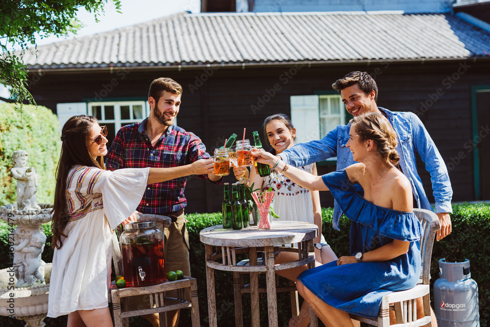 Freunde stoßen mit Getränke an - Party im Garten