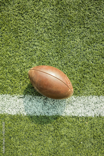 American football ball on the field with line.
