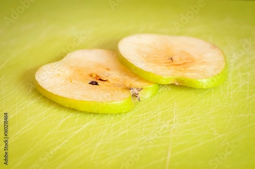 Fotografi Two thin green apple slices on a cutting board turned brown due to the oxidation process close up stock image