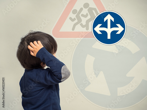 Little boy looks at traffic signs