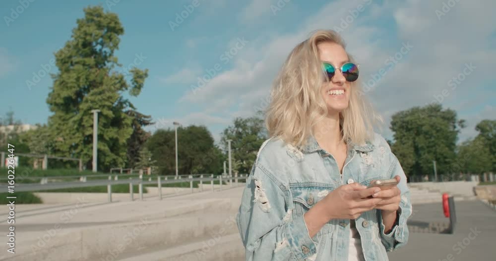 Beautiful young woman typing on phone during sunny day. Beautiful young woman typing on phone during sunny day.