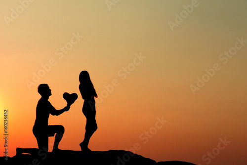 Canvas-taulu Silhouette of attractive confident half naked man propose marriage to bikini wom