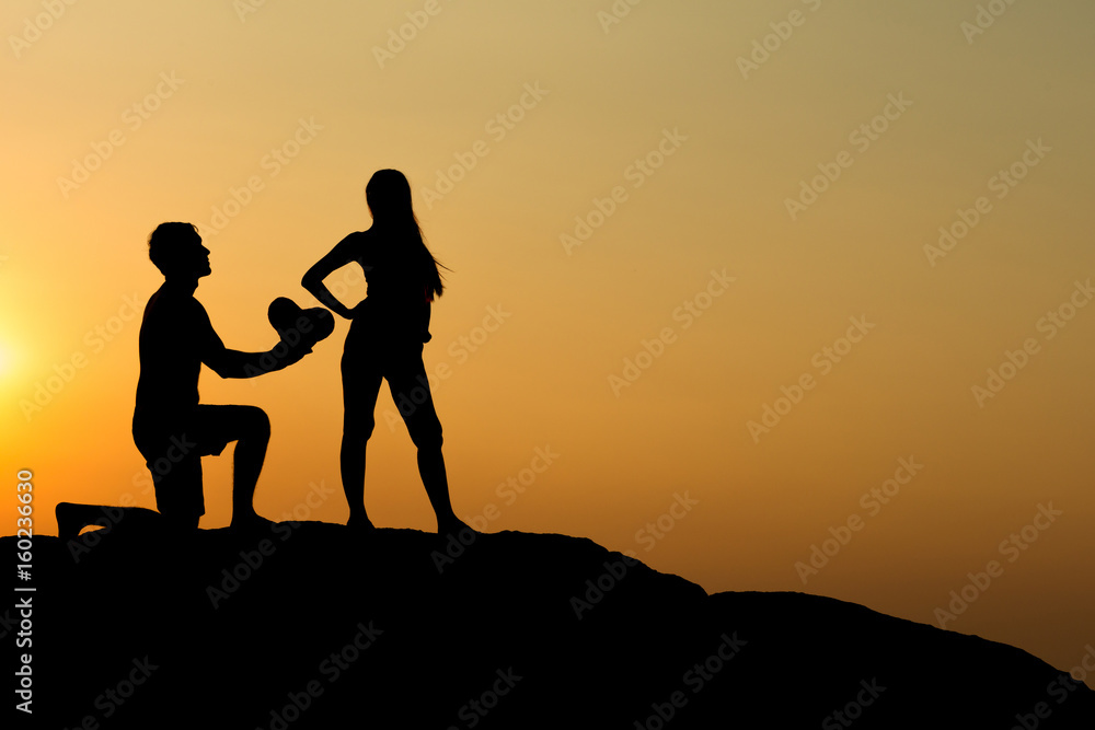 Silhouette of attractive confident half naked man propose marriage to bikini womanSilhouette of attractive confident half naked man propose marriage to bikini woman