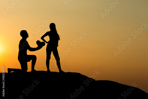 Silhouette of attractive confident half naked man propose marriage to bikini womanSilhouette of attractive confident half naked man propose marriage to bikini woman
