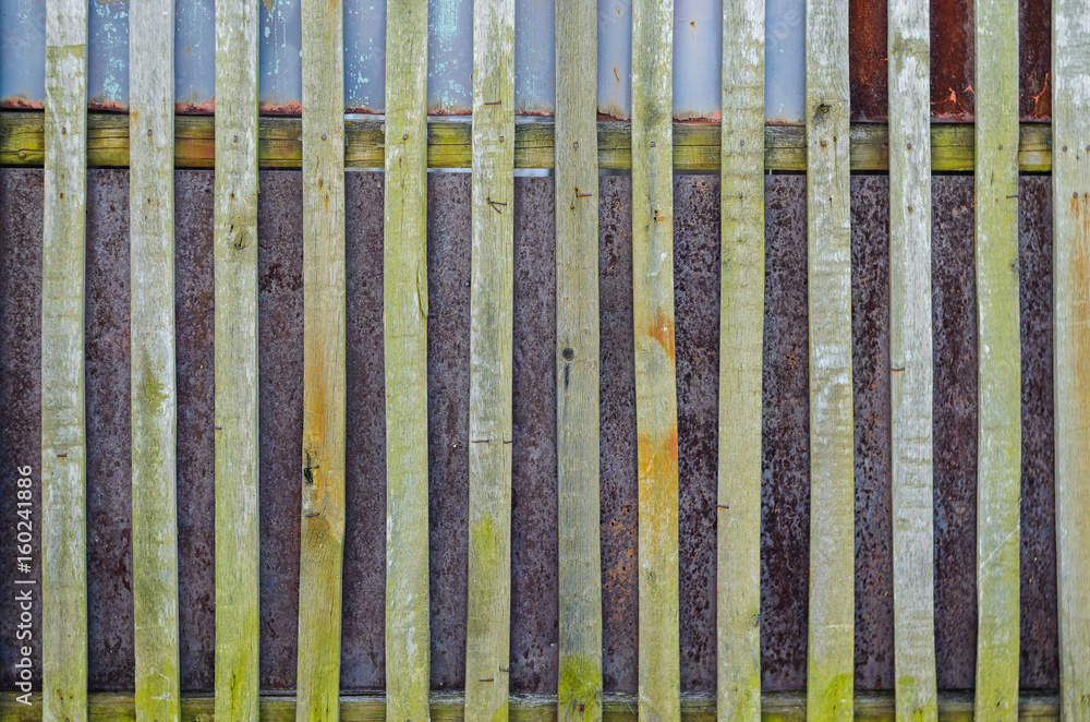 Old fence background. Wooden boards and rusty steel sheets Old fence background. Wooden boards and rusty steel sheets